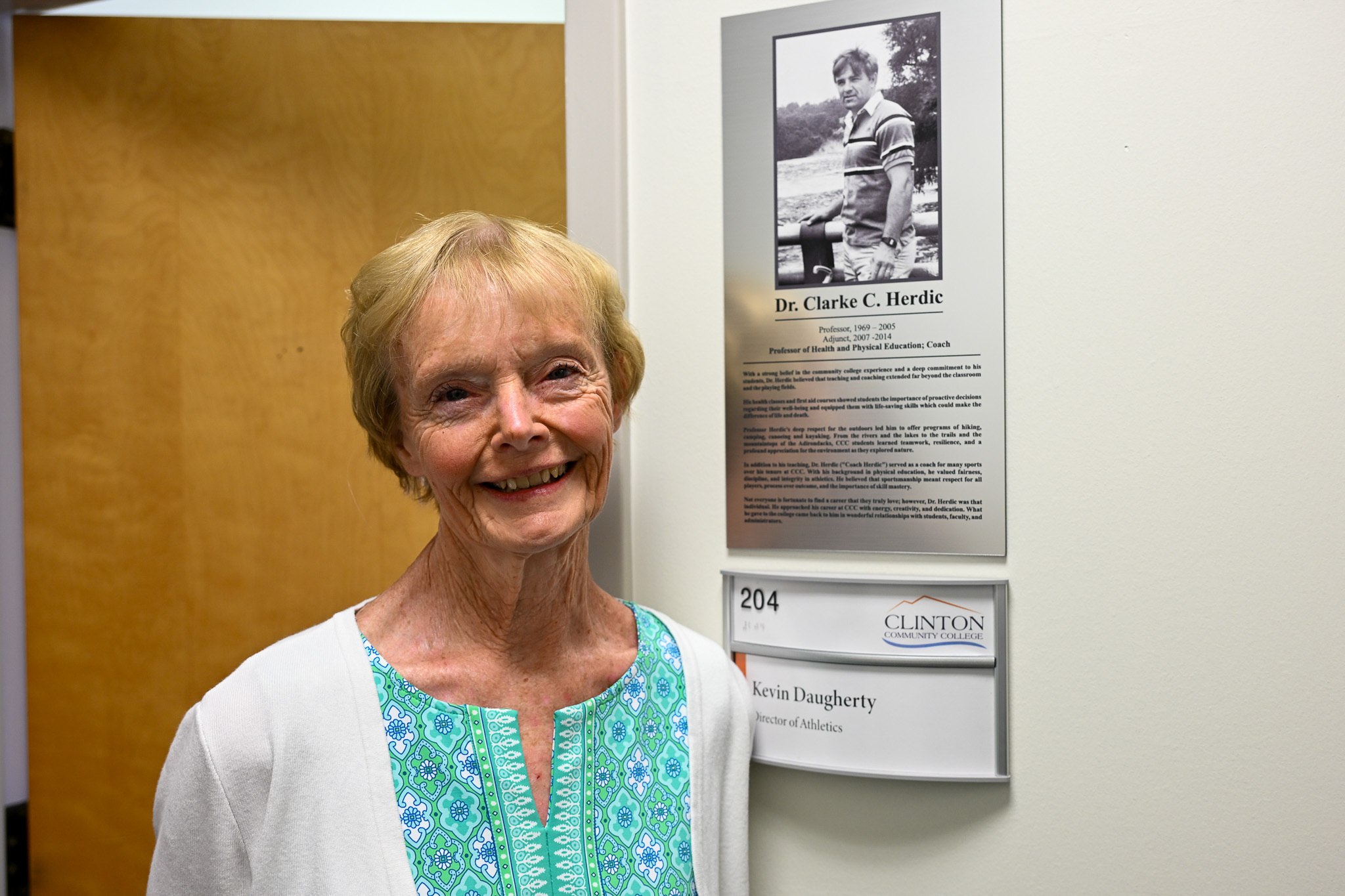 A woman standing next to a plaque on an office